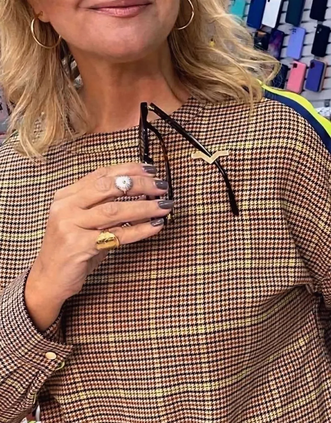 A gold StefMag worn on a houndstooth top, holding a pair of folded sunglasses securely by the temple.