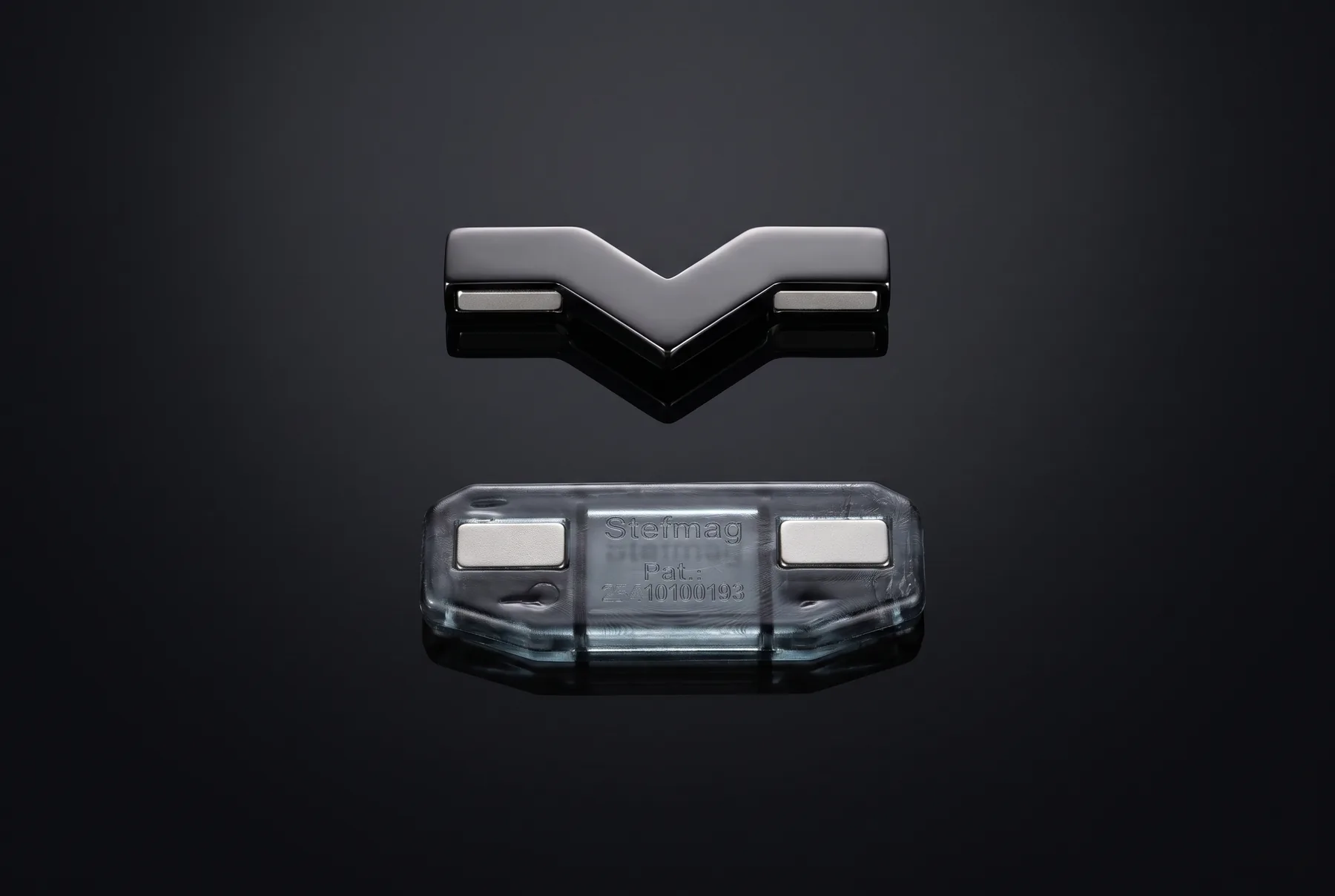 A StefMag separated into its two parts: a polished chrome V lifted above the smoky housing that holds four neodymium magnets.